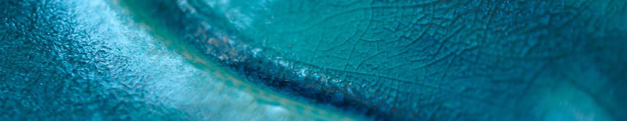 Oberfläche einer in Petrol glasierten Keramik in Form einer Welle