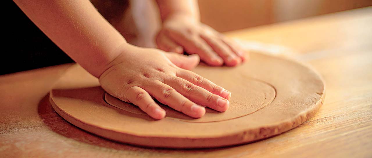 Kinderhände drücken auf eine Tonplatte